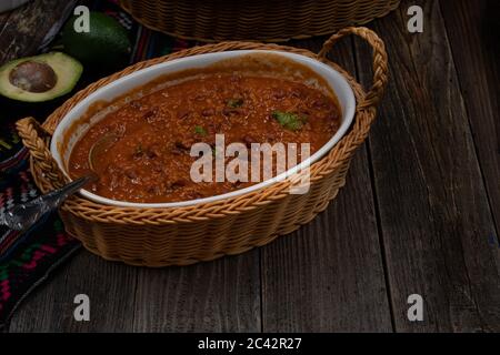 Vegane Chili mit Seitan und Bohnen in weißen Keramikschale auf Holztisch, kopieren Raum Stockfoto