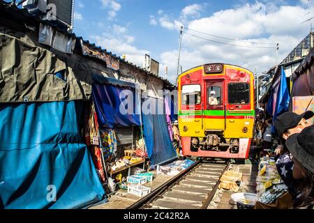 MAEKLONG/THAILAND-NOVEMBER 28 2019: Zug durch Maeklong Bahnmarkt - eine berühmte Touristenattraktion direkt außerhalb von Bangkok Stockfoto