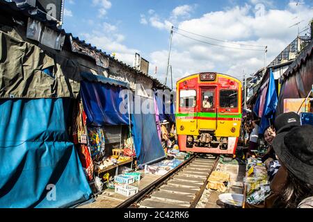 MAEKLONG/THAILAND-NOVEMBER 28 2019: Zug durch Maeklong Bahnmarkt - eine berühmte Touristenattraktion direkt außerhalb von Bangkok Stockfoto