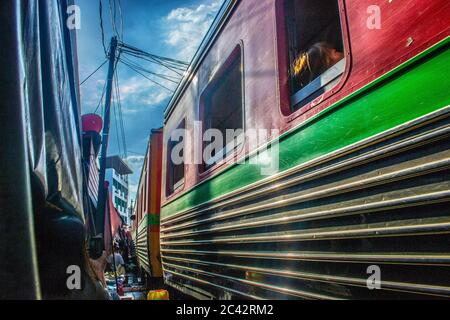 MAEKLONG/THAILAND-NOVEMBER 28 2019: Zug durch Maeklong Bahnmarkt - eine berühmte Touristenattraktion direkt außerhalb von Bangkok Stockfoto