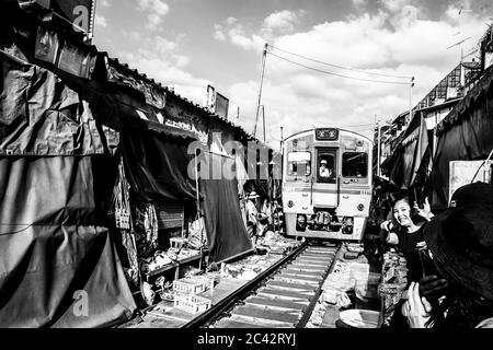 MAEKLONG/THAILAND-NOVEMBER 28 2019: Zug durch Maeklong Bahnmarkt - eine berühmte Touristenattraktion direkt außerhalb von Bangkok Stockfoto