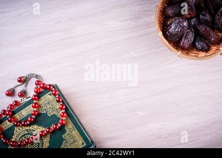 Flache Lay-Zusammensetzung aus Qoran und Tasbih (Rosenkranz). Die Worte auf dem Qoran sind arabisch, was den Heiligen Qoran bedeutet Stockfoto