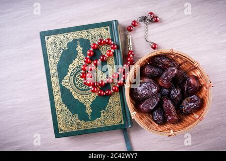 Flache Lay-Zusammensetzung aus Qoran und Tasbih (Rosenkranz). Die Worte auf dem Qoran sind arabisch, was den Heiligen Qoran bedeutet Stockfoto