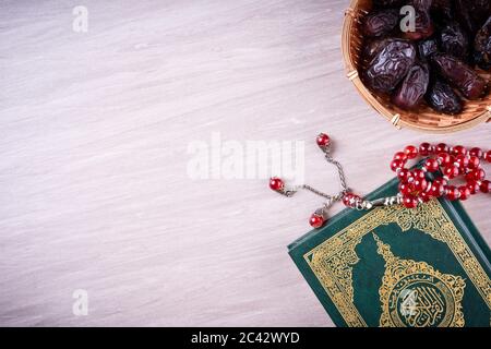 Flache Lay-Zusammensetzung aus Qoran und Tasbih (Rosenkranz). Die Worte auf dem Qoran sind arabisch, was den Heiligen Qoran bedeutet Stockfoto