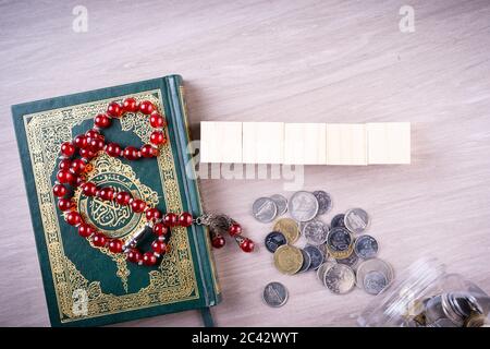 Flache Lay-Zusammensetzung aus Qoran und Tasbih (Rosenkranz). Die Worte auf dem Qoran sind arabisch, was den Heiligen Qoran bedeutet Stockfoto