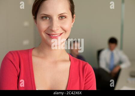 Junge Frau vor zwei Geschäftsleuten in einem Büro - schauen Sie Stockfoto