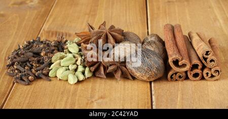 Haufen trockenes Gewürz Nelken, Haufen von trockenen verstreut unraffinierte Kardamom Samen, Bündel trockenen Anis Spice, getrocknet Muskatnuss Früchte, chemische Zimtstangen, liegen auf Stockfoto