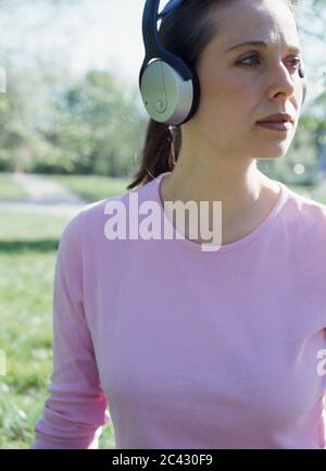 Frau mittleren Alters hört Musik auf Kopfhörern Stockfoto