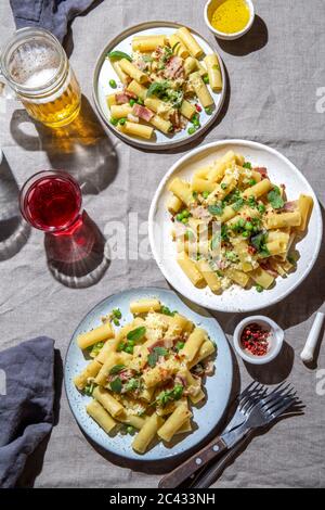 Italienisches Rezept Pasta Tortilloni mit grüner Erbse, Minzblätter geräucherter Speck und Käse. Stockfoto