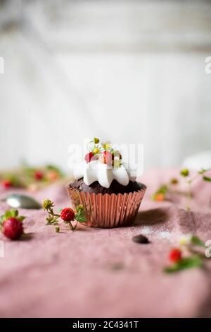 Schokoladenkuchen mit Schlagsahne und Erdbeeren auf dem Tisch. Stockfoto