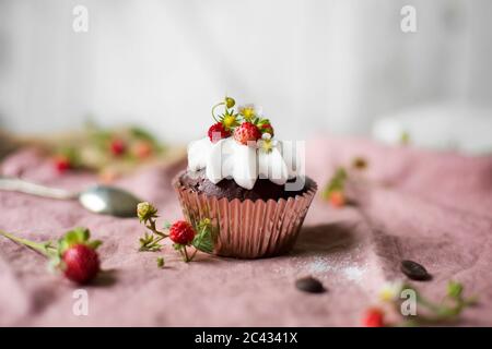 Schokoladenkuchen mit Schlagsahne und Erdbeeren auf dem Tisch. Stockfoto