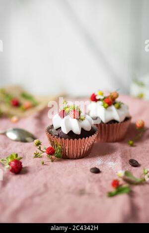 Schokoladenkuchen mit Schlagsahne und Erdbeeren auf dem Tisch. Stockfoto