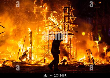 Silhouette der Feuerwehrmann versuchen, ein Feuer in einer Straße in einer Nacht zu steuern. Stockfoto