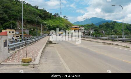 Macara, Loja / Ecuador - 4. April 2019: Fahrzeuge im Umlauf auf der internationalen Brücke von Macara an der Grenze zwischen Ecuador und Peru Stockfoto