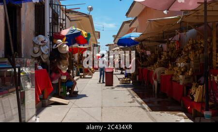 Catacaos, Piura / Peru - 6. April 2019: Touristen, die auf einer Straße voller Handwerksbetriebe im Zentrum der Stadt Catacaos spazieren Stockfoto