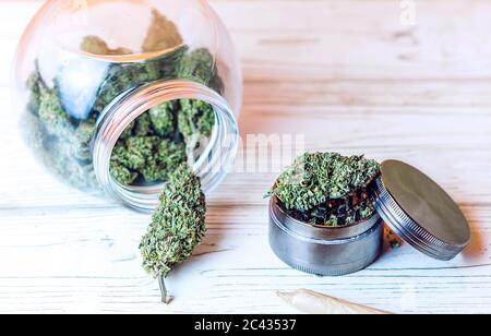 Cannabis Blüten Knospen in Glas und Mühle auf dem Tisch Stockfoto