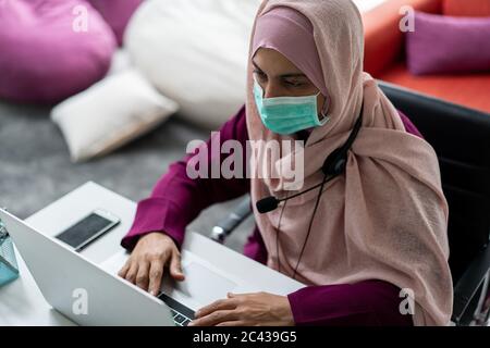 Muslimische Frau zu Hause mit Video-Meeting Stockfoto