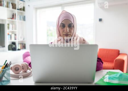 Muslimische Frau zu Hause mit Video-Meeting Stockfoto