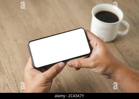 Draufsicht Mockup Bild Hand mit einem Smartphone Mann Holding Handy mit leeren Bildschirm Stockfoto