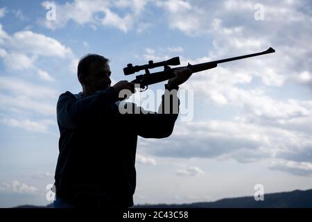 Mann mit Gewehr und Scharfschütze Silhouette Stockfoto