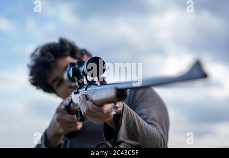 Junger Mann mit Gewehr und Scharfschütze Stockfoto