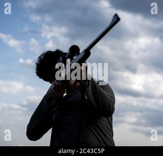 Junger Mann mit Gewehr und Scharfschütze Stockfoto