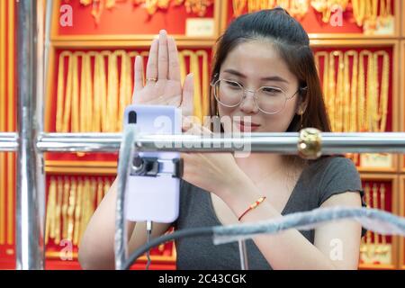Asiatische schöne Frau verkauft Gold Zubehör online von Live-Streaming. Verkauf es online Live-Streaming-Konzept Stockfoto