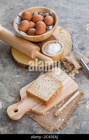 Hausgemachtes Vollkornbrot mit Kochwerkzeugen und Zutaten. Stockfoto