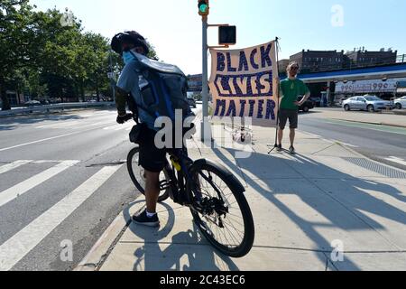 New York City, USA. Juni 2020. Sam Kuik hält ein selbstgebackenes Schild "Black Lives Matter" entlang des Queens Boulevard im Sunnyside-Teil von Queens, NY, 23. Juni 2020. Der Tod von George Floyd, der am 25. Mai von der Minneapolis-Polizei getötet wurde, hat zu Protesten im ganzen Land und auf der ganzen Welt zur Unterstützung der Bewegung Black Lives Matter geführt, um gegen systemischen Rassismus und Polizeibrutalität zu stehen.(Anthony Behar/Sipa USA) Credit: SIPA USA/Alamy Live News Stockfoto