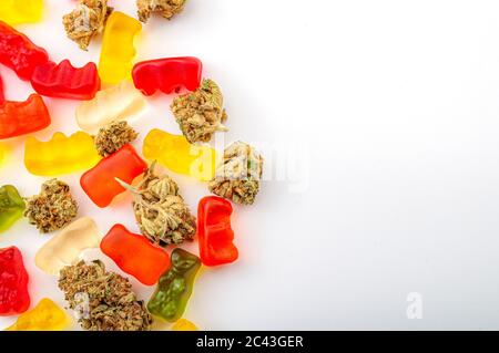 Cannabis Esswaren, medizinisches Marihuana, CBD-infundierte Gummis und essbare Topf-Konzept-Thema mit Nahaufnahme von bunten Gummibären und Unkrautknospen auf weißem Bac Stockfoto