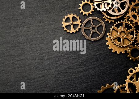 Steampunk Accessoires und alte Technik Konzeptidee mit Rand aus einer Gruppe Messing Zahnräder auf dunklem Textur Hintergrund mit Kopierer Platz gemacht Stockfoto