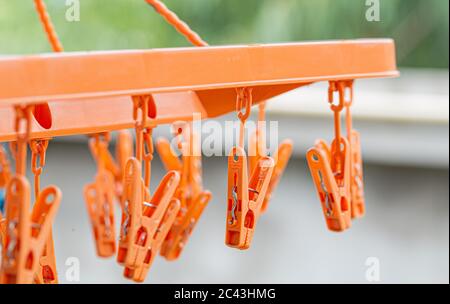 Orangefarbene Kunststoff-Wäscheklammern auf den Kleiderbügeln, Wäscheklammern auf den Kleiderbügeln für Wäsche. Stockfoto