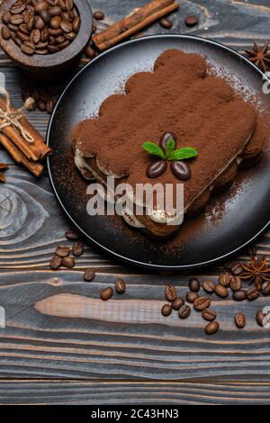 Klassisches Tiramisu Dessert auf Keramikplatte auf Holzhintergrund Stockfoto