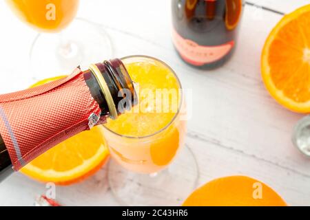 Üppige Mixgetränke, sommerliche alkoholische Getränke und erfrischendes Brunch Mimosa Cocktail-Konzept mit Blick von oben auf Orangenfrüchte und Champagner Gießen von bo Stockfoto