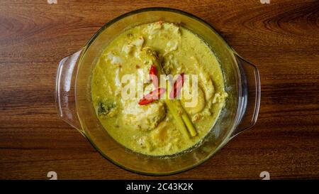 Telur Masak Lemak Cili PADI oder Ei in Kokosnusscreme mit Vogelperlchen in Englisch, ist eine würzige, reiche gelbe Kokosnusssoße, die mit Chili p gekocht wird Stockfoto