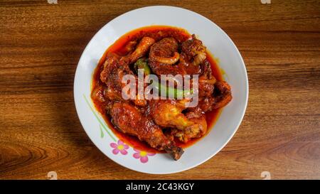 Ayam masak merah ist ein malaysisches traditionelles Gericht. Das bedeutet wörtlich Huhn "gekocht-rot" in Englisch. Es ist eine Auflaufform von Hühnerstücken in getrockneten c Stockfoto