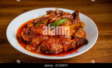 Ayam masak merah ist ein malaysisches traditionelles Gericht. Das bedeutet wörtlich Huhn "gekocht-rot" in Englisch. Es ist eine Auflaufform von Hühnerstücken in getrockneten c Stockfoto