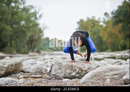 Frau beim Handstand an der Isar, München, Bayern, Deutschland Stockfoto