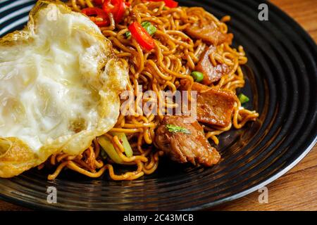 Dry Instant Noodle, malaysische maggi Goreng mamak oder würzige Dry Curry Instant Nudeln mit sonnigen Seite up Ei und Rindfleisch. Stockfoto