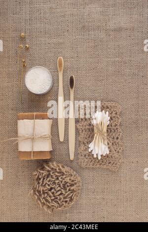 Vertikale Zusammensetzung mit natürlichen Bad-Tools, nachhaltige Lifestyle-Konzept. Holzzahnbürsten, Bambusstäbchen, Bio-Seife, Zahnpulver, Jute Stockfoto