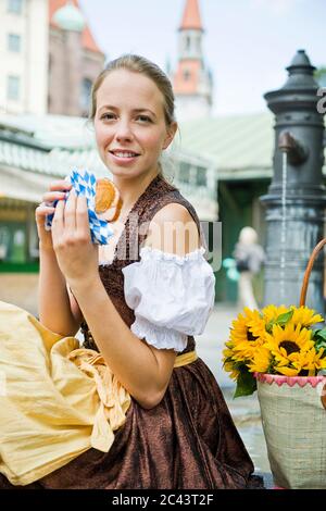 Junge Frau im Dirndl mit Leberkäs Brötchen Stockfoto