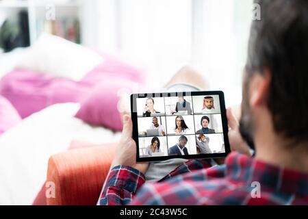 Mann zu Hause mit Online-Chat mit Arbeitskollegen auf Tablet Stockfoto