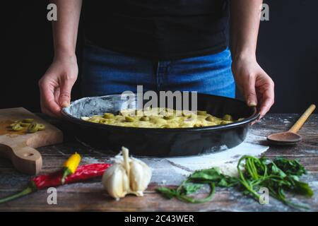 Junge Frau, die Focaccia, italienisches Fladenbrot macht. Koch- und Backkonzept, italienische hausgemachte Speisen Stockfoto