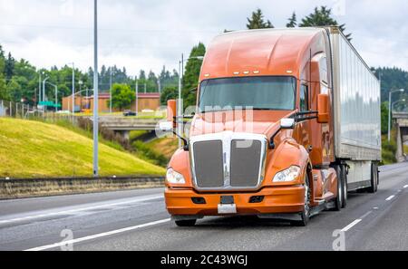 Bright Brown professionelle große Rig Motorhaube Langstrecke Diesel semi Truck Transport von gewerblichen Fracht in trockenen van Sattelauflieger bewegt sich auf der geraden breit Stockfoto