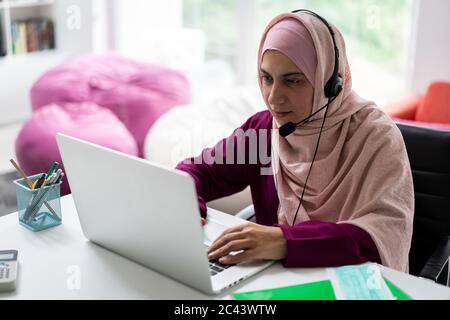 Muslimische Frau zu Hause mit Video-Meeting Stockfoto