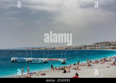 Nizza, Frankreich - 14. Juni 2019 : Touristen genießen ihren Tag am Strand von Nizza, an der französischen riviera. Stockfoto