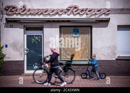 Torgelow, Deutschland. Juni 2020. Ein Kind fährt mit seinem Roller an dem geschlossenen Blumenladen mit Resten von Werbeschildern in der Friedrichstraße vorbei. Die kleine Stadt, die 1281 erstmals erwähnt wurde und heute etwa 9,000 Einwohner zählt, wurde einst als Handelszentrum am Zusammenfluss von Uecker und Randow gegründet. Viele Wohnungen und Geschäfte in der Altstadt sind heute leer. Quelle: Jens Büttner/dpa-Zentralbild/ZB/dpa/Alamy Live News Stockfoto