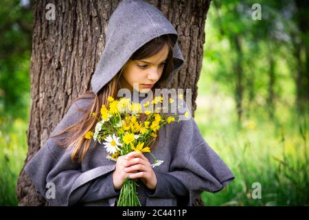 Mädchen hält Bündel von gelben Wildblumen Stockfoto