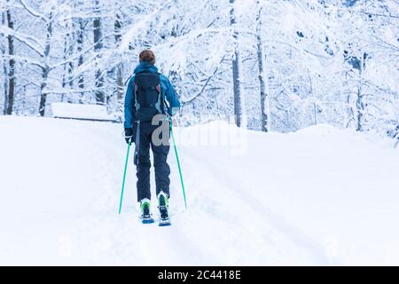 Deutschland, Bayern, Reit im Winkl, Backpacker-Skifahrerin im Winterwald Stockfoto