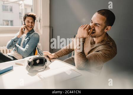 Junge Geschäftsleute arbeiten zusammen im Büro, telefonieren Stockfoto